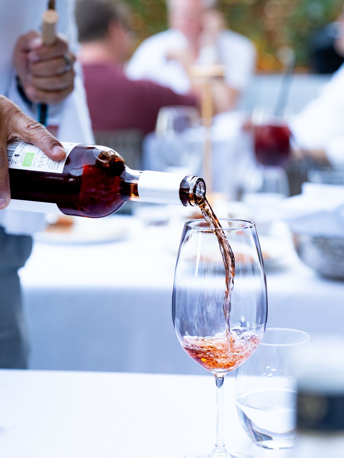 Camarero sirviendo vino rosado en la terraza