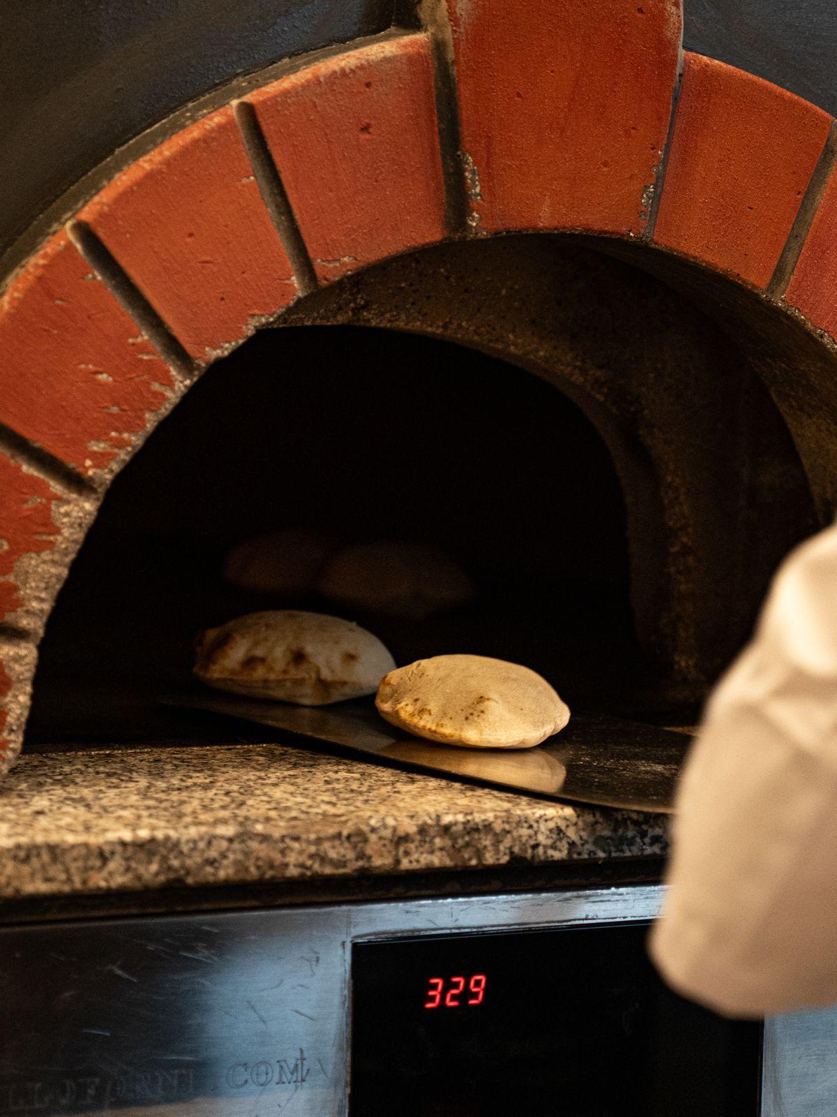 Pan recién horneado saliendo del horno de leña